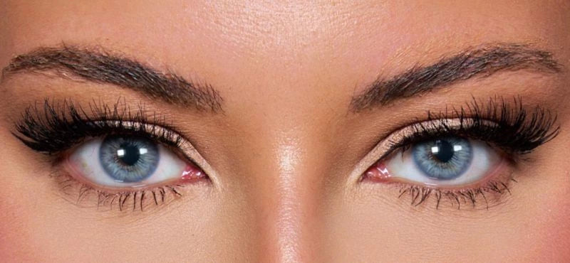 Front view of a model wearing vibrant blue colored contact lenses paired with dramatic lashes and soft glam makeup – a bold, mesmerizing look by KIISBEAUTY.