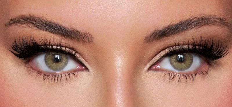 Front view of a model wearing natural green colored contact lenses paired with dramatic lashes and soft glam makeup – a bold, mesmerizing look by KIISBEAUTY.