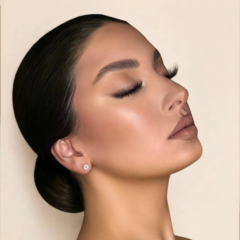 Glamorous side profile of a woman wearing KB Premium Lashes with a sleek bun and glowing makeup