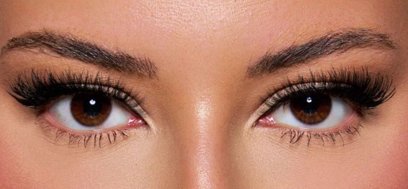 Front view of a model wearing with natural eyes paired with dramatic lashes and soft glam makeup – a bold, mesmerizing look by KIISBEAUTY.